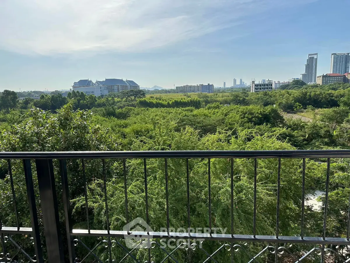 Stunning panoramic view from balcony overlooking lush greenery and cityscape.