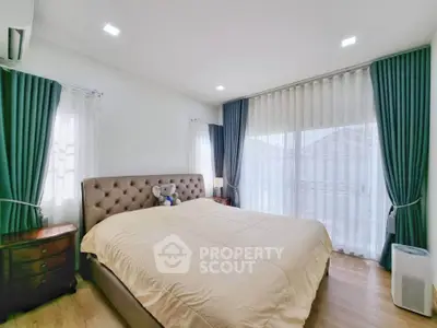 Spacious bedroom with elegant decor and large windows for natural light.