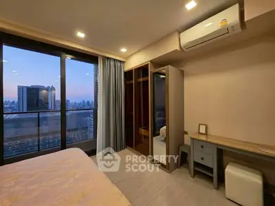 Modern bedroom with city view and balcony access, featuring sleek furniture and ample natural light.