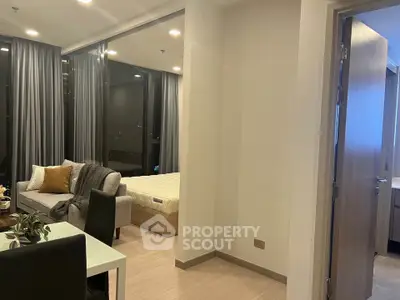 Modern open-plan living room with cozy sofa and elegant bedroom view, perfect for urban living.