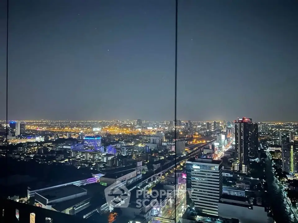 Stunning cityscape night view from high-rise building showcasing vibrant urban lights.