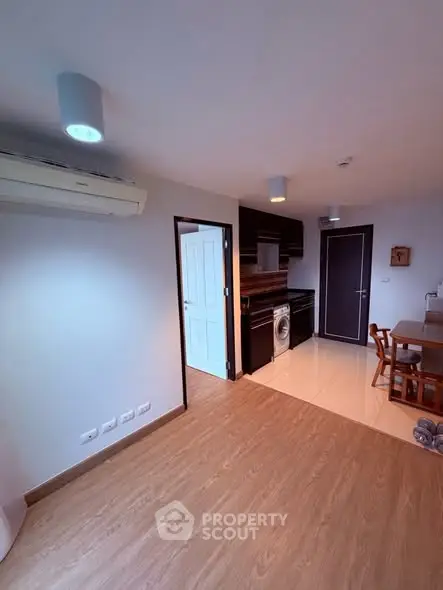 Modern open-plan kitchen with wooden flooring and sleek appliances