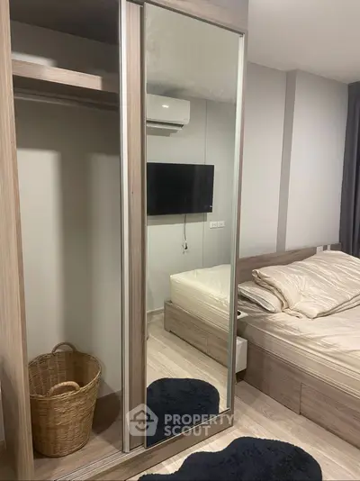 Modern bedroom with mirrored wardrobe and wall-mounted TV