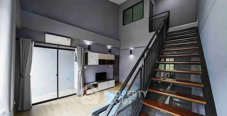 Modern duplex living room with high ceilings and stylish staircase