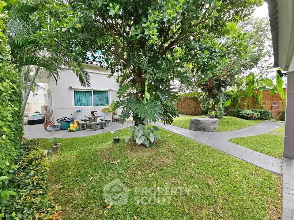 Charming garden view with lush greenery and paved pathways in a serene residential setting.