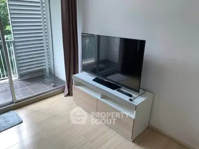 Modern living room with sleek TV stand and balcony access