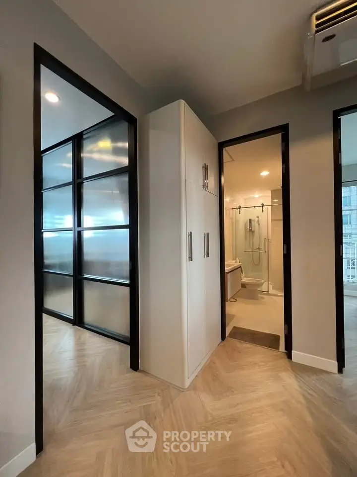 Modern apartment interior with sleek design and spacious layout, featuring a bathroom and storage area.