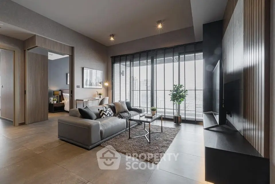 Modern living room with sleek design, large windows, and stylish furniture in a high-rise apartment.