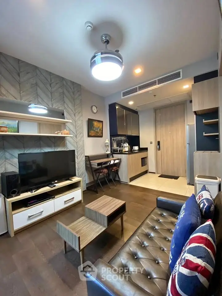Modern living room with stylish decor and open kitchen layout in a cozy apartment.