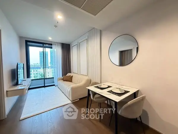 Modern living room with elegant decor and balcony view in a stylish apartment.