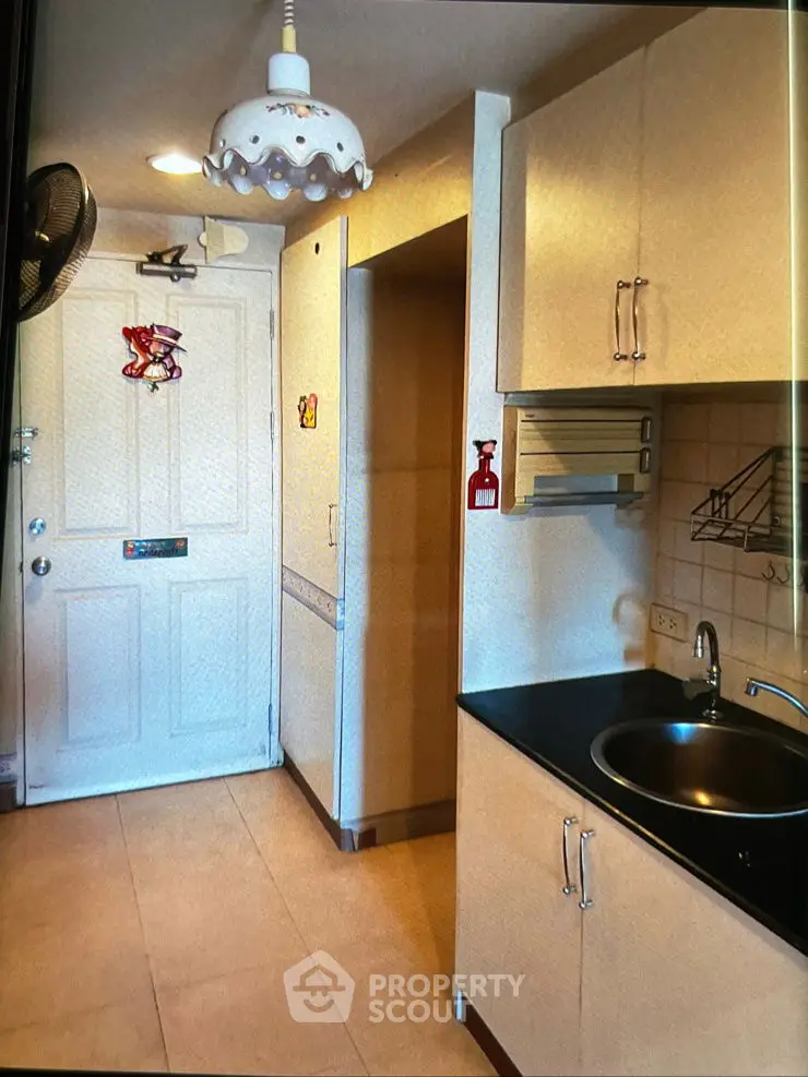 Compact kitchen with modern cabinetry and sleek black countertop