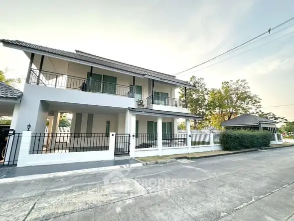 Modern two-story house with spacious balcony and fenced yard in serene neighborhood.