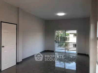 Spacious empty room with large window and balcony access, perfect for customization.