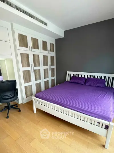 Spacious bedroom with modern furniture and ample storage in a stylish apartment.
