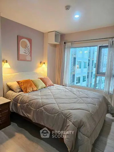 Cozy bedroom with modern decor and large window offering city view