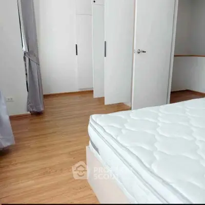 Spacious bedroom with wooden flooring and large wardrobe, perfect for modern living.