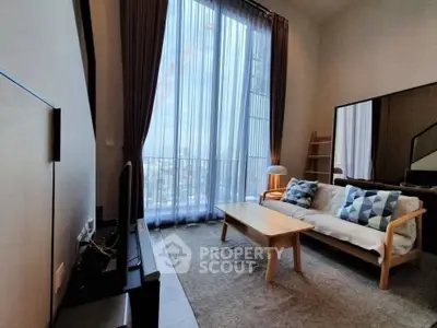 Modern living room with high ceilings and large windows offering city views.