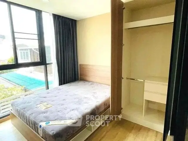 Cozy bedroom with large window and built-in closet in modern apartment