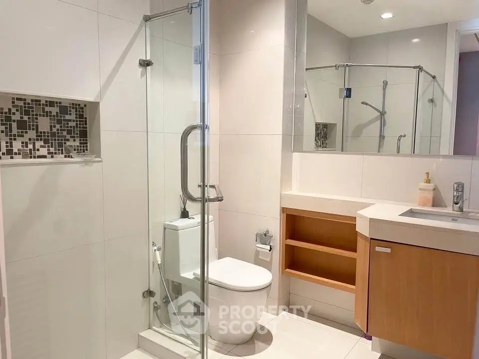 Modern bathroom with glass shower and sleek vanity in a contemporary home.