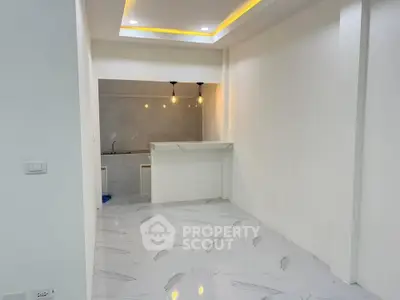 Modern minimalist kitchen with sleek marble flooring and stylish lighting.