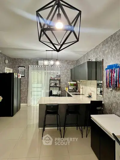 Modern kitchen with sleek black cabinets and geometric pendant lighting