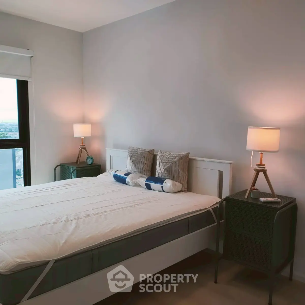 Modern bedroom with stylish decor and large window offering natural light.