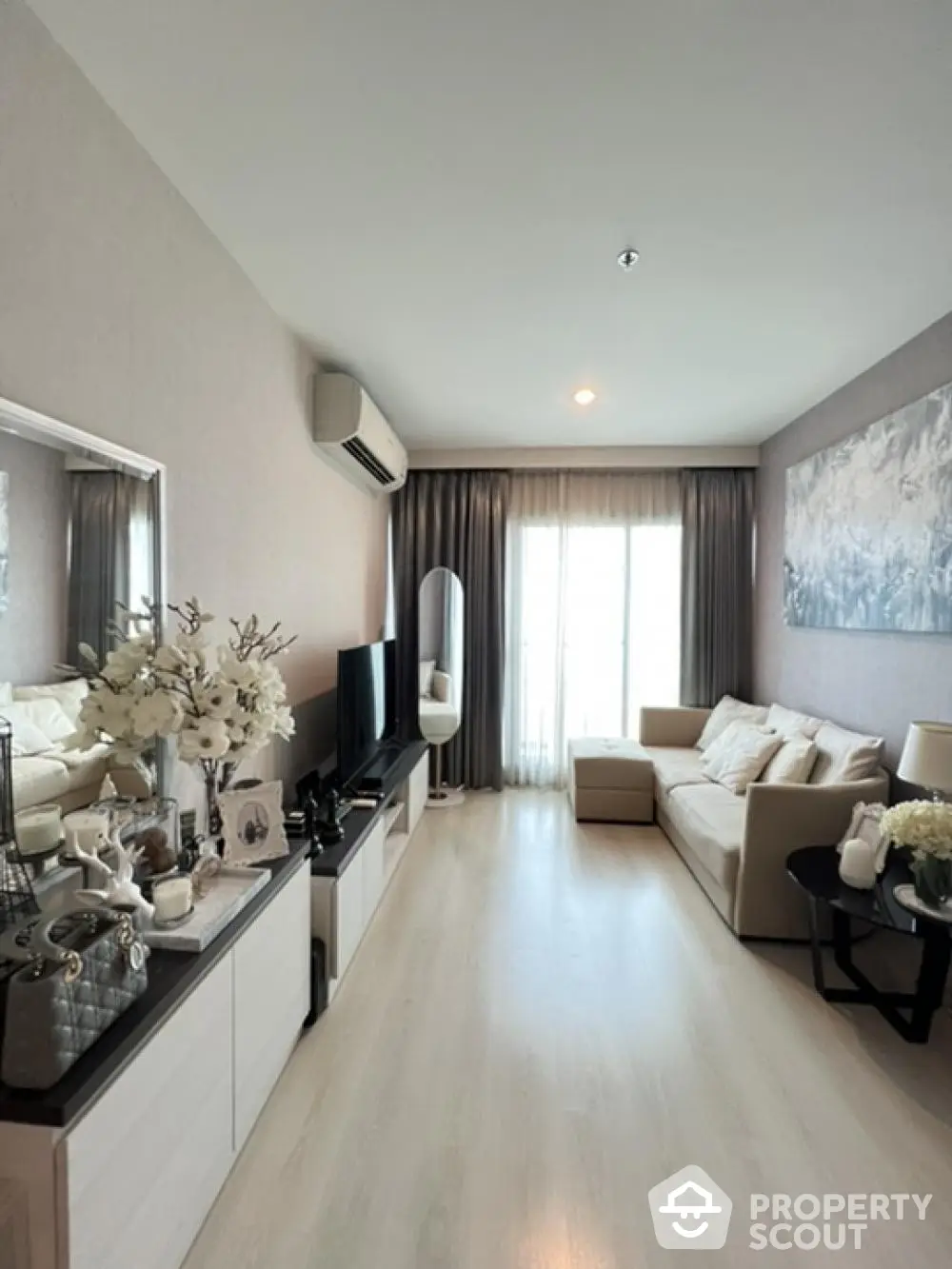 Elegant living room with modern furnishings, sleek white flooring, and tasteful decor creating a serene and inviting atmosphere for relaxation and entertainment.