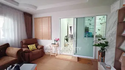 Cozy living room with elegant decor and sliding glass doors leading to a bright space.