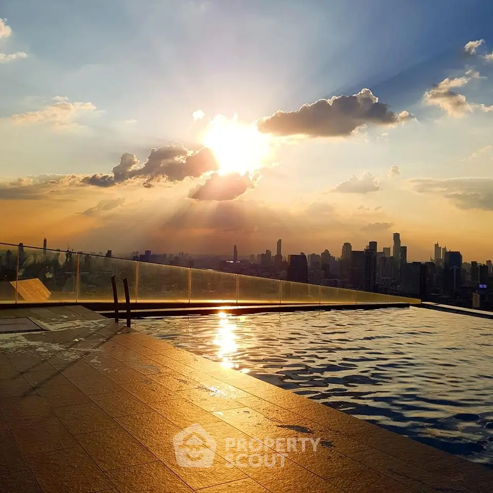 Stunning rooftop pool with breathtaking city skyline view at sunset.
