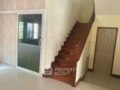 Charming interior with wooden staircase and sliding glass door, perfect for cozy living.