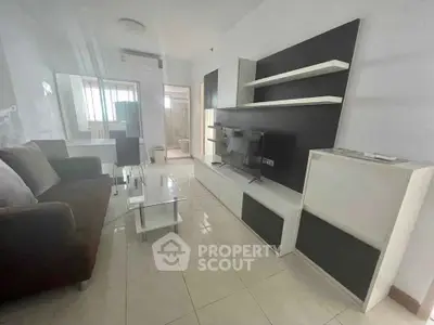 Modern living room with sleek furniture and wall-mounted TV in a bright apartment.