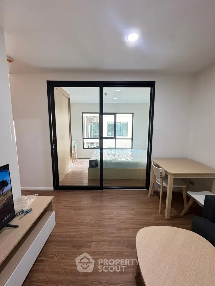 Modern studio apartment with wooden flooring and sliding glass doors
