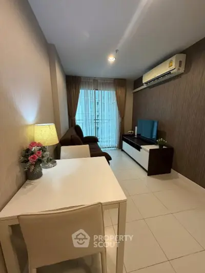 Modern living room with stylish decor, air conditioning, and natural light from large window.