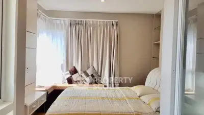 Cozy bedroom with natural light and stylish decor, featuring a comfortable bed and window seating area.