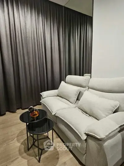 Cozy living room with plush sofa and elegant curtains, perfect for relaxation.