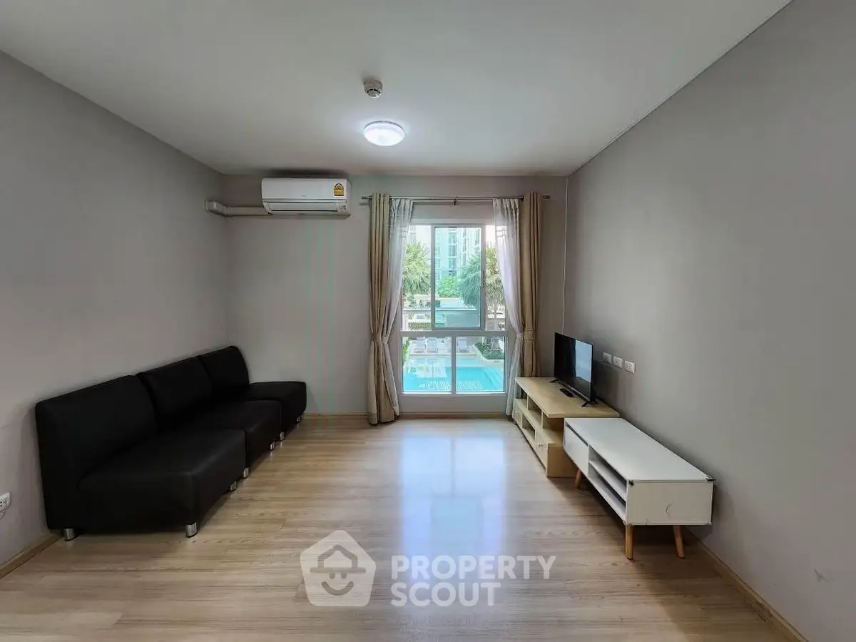 Spacious living room with modern furniture and pool view, perfect for relaxation and entertainment.