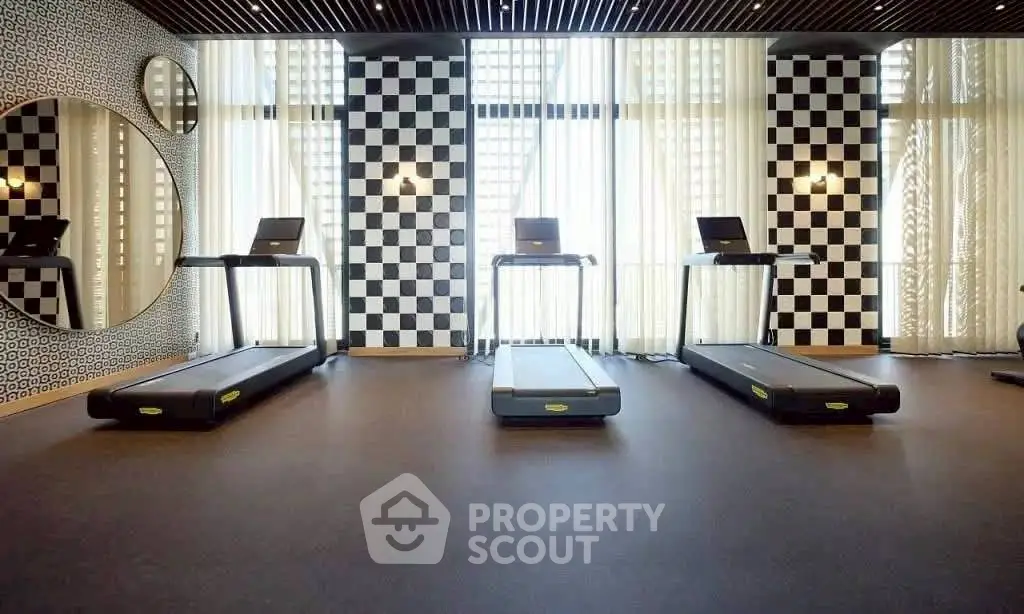 Modern gym with treadmills and stylish checkered wall design