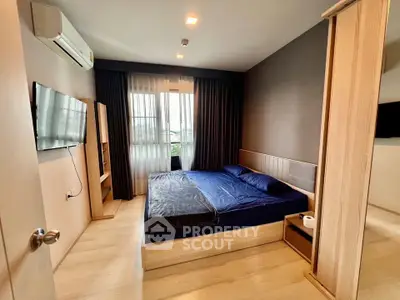 Modern bedroom with sleek design, featuring a large bed, wall-mounted TV, and ample natural light.