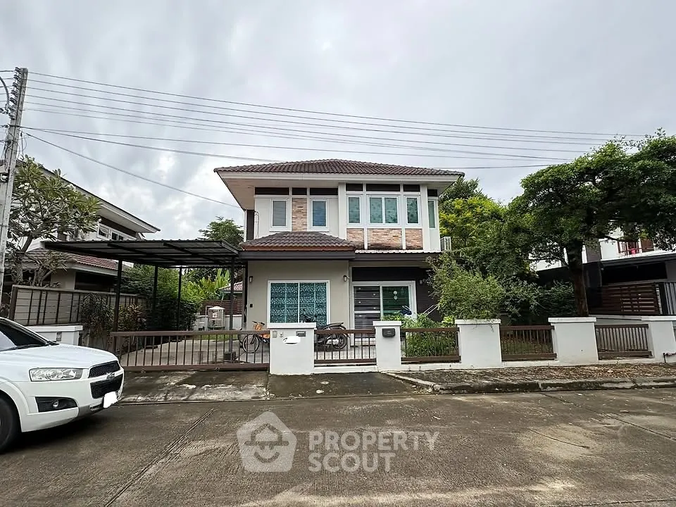 Charming two-story house with modern design and lush greenery in a serene neighborhood.