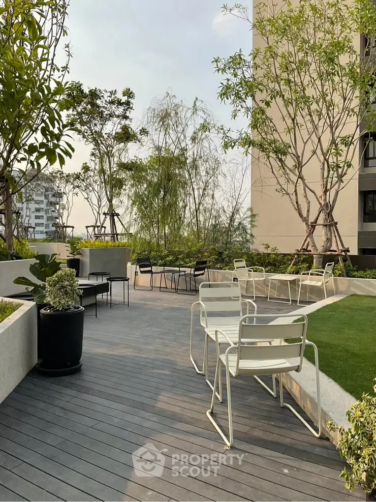 Modern rooftop garden with stylish seating and lush greenery in urban setting.