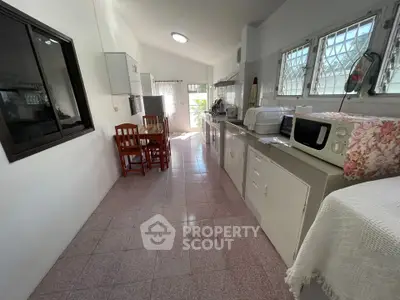 Spacious kitchen with natural light, featuring modern appliances and dining area.