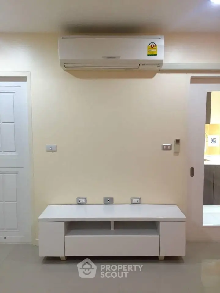 Modern living room with air conditioning and sleek white furniture, perfect for comfortable living.