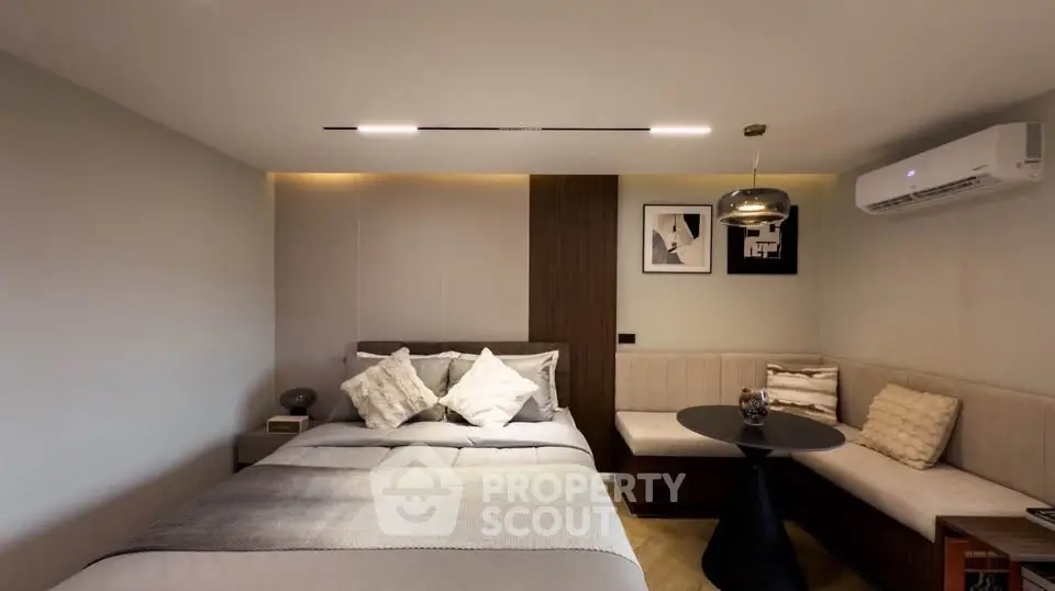 Modern bedroom with cozy seating area and stylish decor