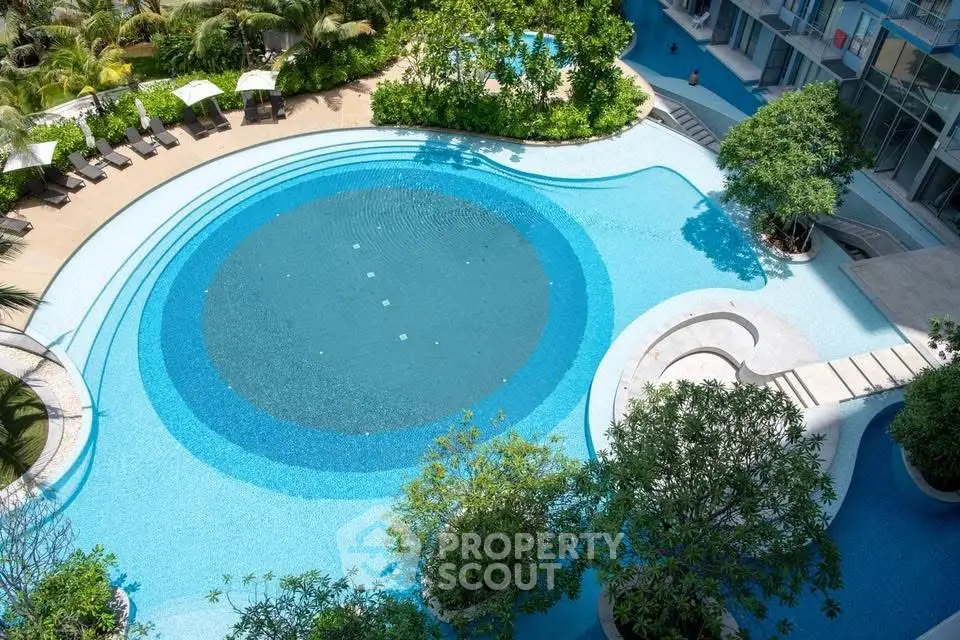 Luxurious resort-style swimming pool with lush greenery and modern design.