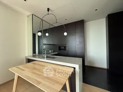 Modern kitchen with sleek dark cabinets and stylish pendant lighting