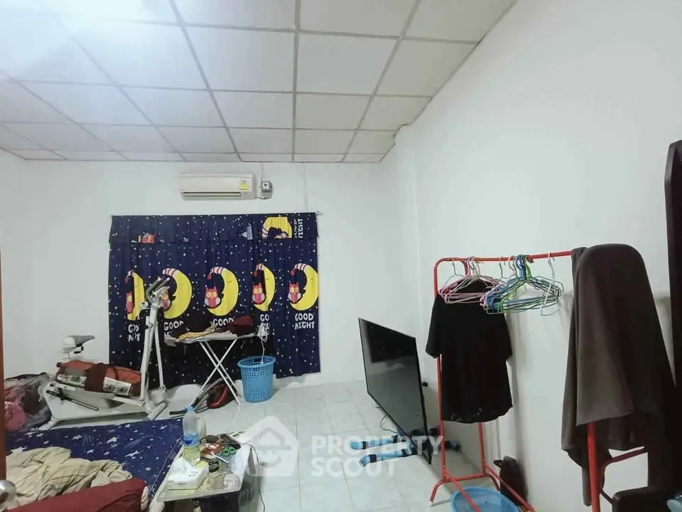 Cozy bedroom with unique moon-themed curtains and practical storage solutions.