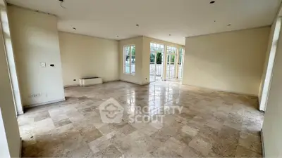Spacious empty living room with large windows and marble flooring