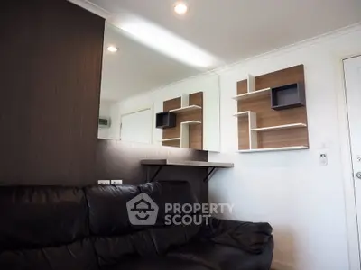Modern living room with sleek black leather sofa and stylish wall shelves