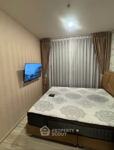 Modern bedroom with stylish decor and wall-mounted TV