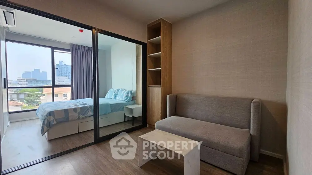 Modern apartment interior with cozy living room and bedroom, featuring large windows and stylish furniture.